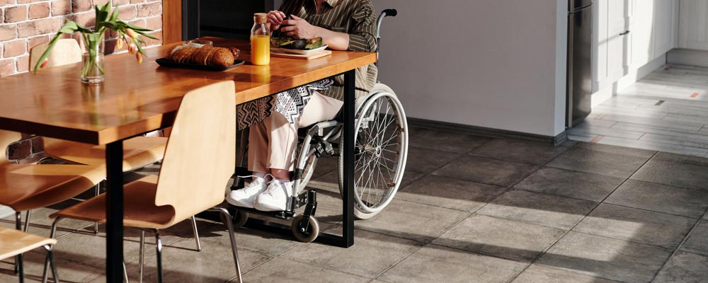 Woman sitting in wheel chair in Specialist Disability Accommodation reading about Returns and Hurdle Rates.